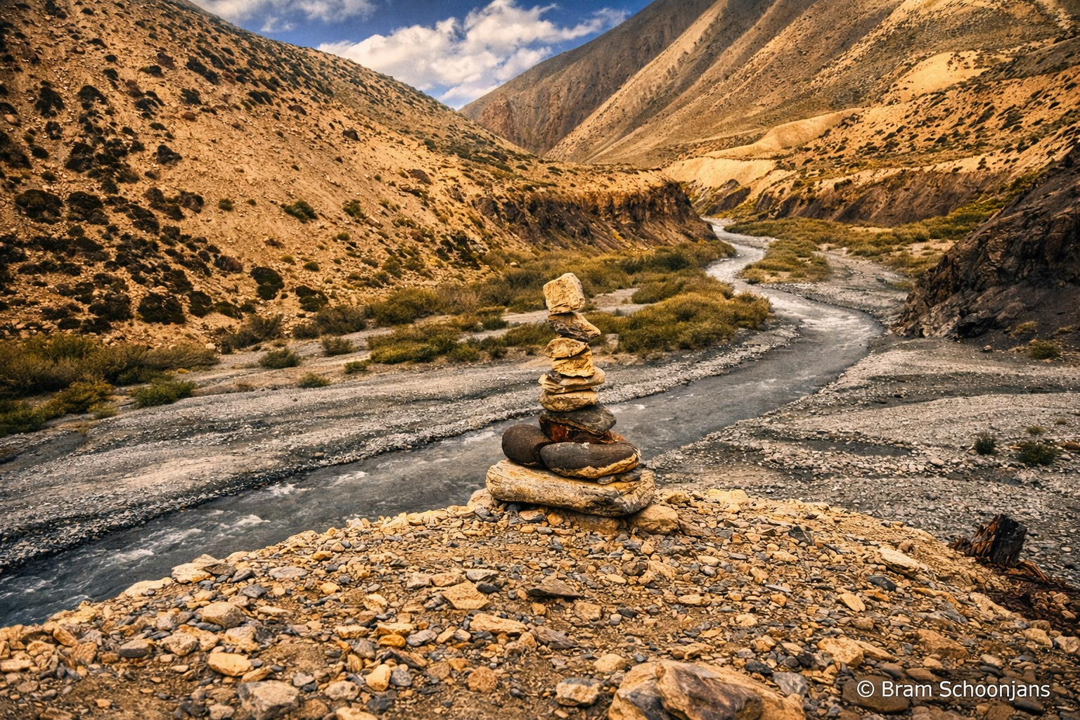 Stone cairn beside a winding river in a wide Zanskar valley